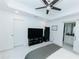 Bedroom with sliding barn door to bath, TV, and trey ceiling with ceiling fan at 9404 N 12Th St, Tampa, FL 33612