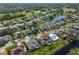 Aerial view showing a waterfront property near a golf course, with a well-maintained street and lush tropical landscaping at 13024 Prestwick Dr, Riverview, FL 33579
