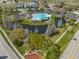 Aerial view showcasing a community pool and clubhouse surrounded by landscaping and a tranquil pond with a fountain at 13024 Prestwick Dr, Riverview, FL 33579