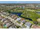Aerial view showcasing a waterfront community, nearby golf course, and mature landscaping, offering beautiful curb appeal at 13024 Prestwick Dr, Riverview, FL 33579