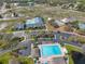 Aerial view highlighting a community pool with surrounding amenities, including tennis courts and a parking area at 13024 Prestwick Dr, Riverview, FL 33579