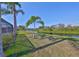 Beautiful backyard with lush green grass, tropical palm trees, and a serene view of the tranquil water at 13024 Prestwick Dr, Riverview, FL 33579