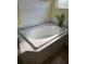 Well-lit bathroom featuring a white soaking tub and tile flooring at 13024 Prestwick Dr, Riverview, FL 33579