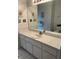 Bathroom with a single sink vanity, large mirror, and striped wallpaper at 13024 Prestwick Dr, Riverview, FL 33579