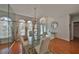 Bright dining area with a glass-top table set, chandelier lighting, and a view of the front entryway at 13024 Prestwick Dr, Riverview, FL 33579