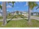 Welcoming home featuring a lush front lawn, mature palm trees, and an inviting facade, creating a charming and tropical curb appeal at 13024 Prestwick Dr, Riverview, FL 33579