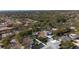 An aerial view showcases the neighborhood with mature trees, single-Gathering homes and community pools at 1883 Brae Moor Dr, Dunedin, FL 34698