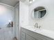 Clean bathroom featuring a classic vanity, large oval mirror, and modern fixtures creating a stylish and functional space at 2606 Oak Cir, Tarpon Springs, FL 34689