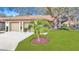 Charming home featuring a two-car garage, well-manicured lawn and mature trees offering a welcoming curb appeal at 2606 Oak Cir, Tarpon Springs, FL 34689