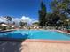 Community pool with clear blue water, poolside seating, and safety fencing at 2606 Oak Cir, Tarpon Springs, FL 34689