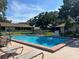 Community pool with lounge chairs for relaxing and fenced for safety at 2606 Oak Cir, Tarpon Springs, FL 34689