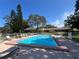 Relaxing community pool with ample seating, surrounded by well-maintained landscaping at 2606 Oak Cir, Tarpon Springs, FL 34689