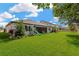 Expansive back yard with lush green lawn, screened in patio, and play set at 2677 Northwood Park St, Valrico, FL 33596