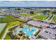 Aerial view of a community pool, clubhouse, and surrounding neighborhood showcasing community amenities at 31675 Cannon Rush Dr, San Antonio, FL 33576
