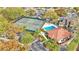 Aerial view showcasing a community pool and tennis courts amidst mature trees and well-maintained landscaping near the condos at 6262 142Nd Ave # 506, Clearwater, FL 33760