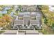Aerial view of townhomes featuring neutral exteriors, private patios, and lush surroundings with sidewalks and a small pond nearby at 6262 142Nd Ave # 506, Clearwater, FL 33760