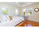 Bright bedroom with three windows, hardwood floors, and a comfortable bed at 705 S Fielding Ave, Tampa, FL 33606