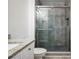 Modern bathroom featuring stone tile shower with glass door and gray flooring at 1216 S Missouri Ave # 224, Clearwater, FL 33756