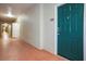 Exterior hallway leading to unit 224, featuring a teal door and neutral walls at 1216 S Missouri Ave # 224, Clearwater, FL 33756