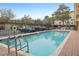 Inviting community pool with brick paver deck, lounge chairs, and mature landscaping at 1216 S Missouri Ave # 224, Clearwater, FL 33756