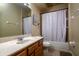 Well-lit bathroom featuring a wood vanity, tile flooring, and a shower-tub combination with neutral-toned walls at 10534 Bermuda Isle Dr, Tampa, FL 33647