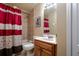 Bathroom featuring a shower-tub combo with a red and white shower curtain at 10534 Bermuda Isle Dr, Tampa, FL 33647