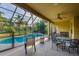 Screened patio offers a dining area, seating, and views of the backyard pool and lush landscaping at 10534 Bermuda Isle Dr, Tampa, FL 33647