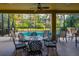 Covered patio with comfortable seating perfect for outdoor dining overlooking the screened pool and lush backyard at 10534 Bermuda Isle Dr, Tampa, FL 33647