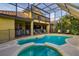 Relaxing backyard pool with a spillover spa, surrounded by a screened enclosure and comfortable seating at 10534 Bermuda Isle Dr, Tampa, FL 33647