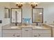 Bathroom featuring double sinks, granite countertops, and matching mirrors at 11209 Bloomington Dr, Tampa, FL 33635