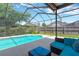 Inviting screened-in pool area with comfortable outdoor seating and lush landscaping at 11209 Bloomington Dr, Tampa, FL 33635