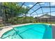 Clear blue in-ground pool in a screened-in enclosure with patio at 11209 Bloomington Dr, Tampa, FL 33635