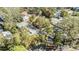 An aerial view showcases the property's tree-filled location and multiple parking spaces at 1157 Brook Rd, Clearwater, FL 33755