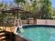 Relaxing backyard pool with a gazebo, wooden deck, and lush greenery, creating a private oasis at 1157 Brook Rd, Clearwater, FL 33755