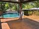 Backyard pool with a covered gazebo, wooden deck, and privacy fence offers a refreshing retreat at 1157 Brook Rd, Clearwater, FL 33755