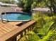 Backyard pool with wooden deck and tropical landscaping offers a relaxing outdoor space at 1157 Brook Rd, Clearwater, FL 33755