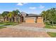 Beautiful single Gathering home with brick driveway, three-car garage, stone accents, and tropical landscaping at 13711 Moonstone Canyon Dr, Riverview, FL 33579