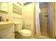 Cozy bathroom featuring a toilet, shower with tan tile, and small sink at 1372 Palmetto St, Clearwater, FL 33755