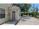 Exterior view featuring light yellow siding, a well-maintained driveway, and lush landscaping at 1372 Palmetto St, Clearwater, FL 33755