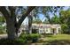 Cozy single-story house with a well-maintained lawn and mature trees, creating a serene setting at 1372 Palmetto St, Clearwater, FL 33755