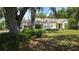 Inviting single-story residence featuring a lovely front lawn and mature trees, perfect for relaxation at 1372 Palmetto St, Clearwater, FL 33755