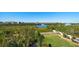 Aerial view of a fenced backyard with a lawn, palms, and community water views at 14554 90Th Ave, Seminole, FL 33776