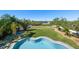Aerial view of a backyard featuring a lush lawn, mature trees, and a sparkling swimming pool, perfect for outdoor enjoyment at 14554 90Th Ave, Seminole, FL 33776