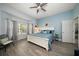This serene bedroom features soft blue walls, a comfortable bed, and abundant natural light from large windows at 14554 90Th Ave, Seminole, FL 33776