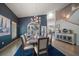 Elegant dining room featuring a modern chandelier, dark blue accent wall and seating for eight at 14554 90Th Ave, Seminole, FL 33776