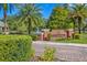 Brick entrance to Club Tampa Palms, lush landscaping, mature palms, and water fountain create a welcoming community atmosphere at 16331 Burniston Dr, Tampa, FL 33647