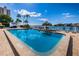 Community pool with waterfront views, lounge chairs, and a tiki hut for relaxation at 3010 59Th S St # 303, Gulfport, FL 33707
