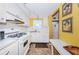 Galley kitchen with white cabinets and appliances, window and eat-in table at 3010 59Th S St # 303, Gulfport, FL 33707
