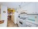 Galley kitchen with white cabinets and appliances, and pass-through to dining room at 3010 59Th S St # 303, Gulfport, FL 33707