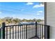 Balcony with a black metal railing overlooking a street and surrounding trees at 4142 N Nebraska Ave, Tampa, FL 33603